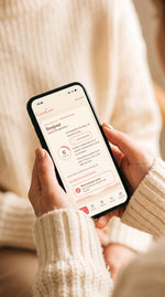 Mains qui tiennent un téléphone ouvert sur l'app Mon rituel CacaoCare