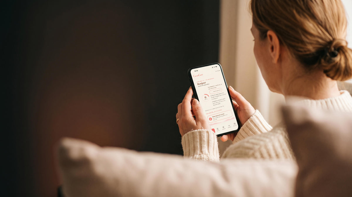 Femme installée sur son canapé, qui consulte l'app Mon rituel CacaoCare sur son téléphone