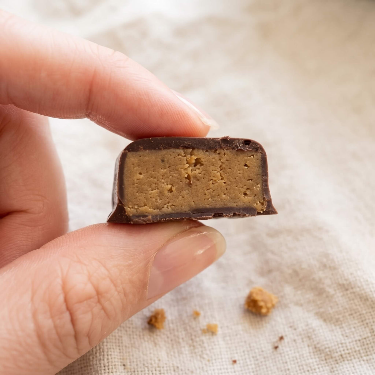 Bouchée Cycle Douceur CacaoCare coupée en deux : chocolat noir et cœur fondant